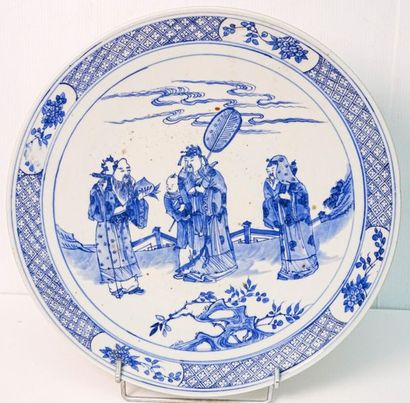 null JAPON - Vers 1900
Plat en porcelaine à décor bleu et blanc de trois sages et...
