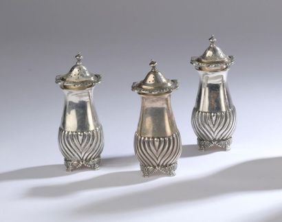 null A series of three silver saltcellars decorated halfway through with gadroons,...
