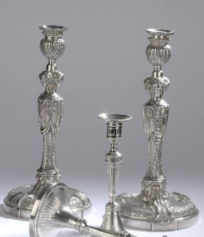 null Pair of silver torches resting on a round base, decorated in repoussé with a...