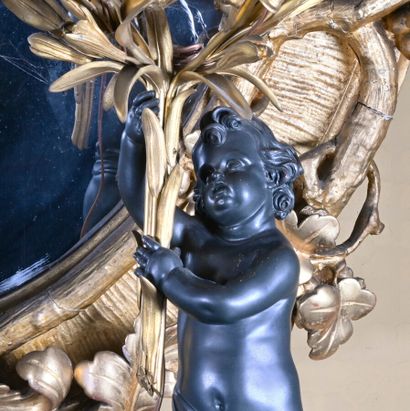 null Pair of gilt patinated bronze candelabra decorated with two putti holding branches...