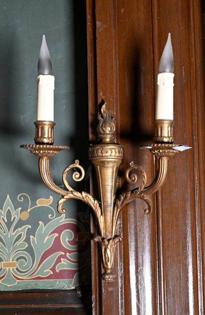 null Suite of four ormolu sconces decorated with flaming torches with two light arms...