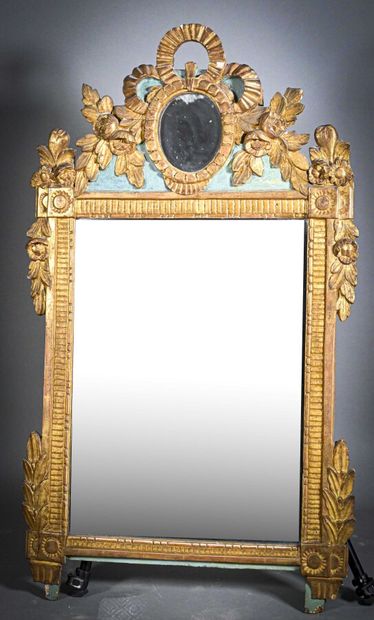null A carved and gilded wood mirror, the pediment decorated with an oval medallion...