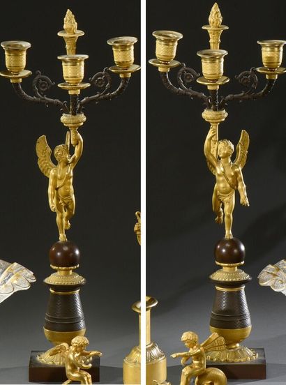 null A pair of ormolu and patinated torchères with winged lovers holding a bouquet...