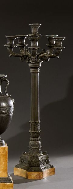 null A pair of large patinated bronze torchères with a fluted shaft on a triangular...
