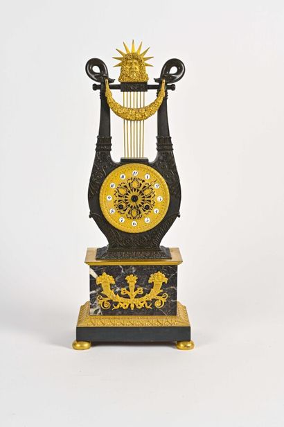 null A gilt bronze and patinated clock with a lyre, ending with swan heads holding...