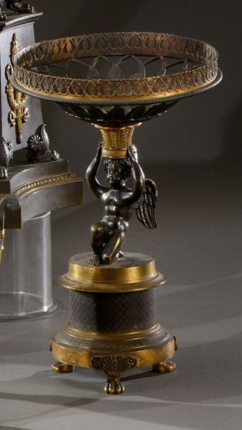 null Beautiful ormolu and patinated centerpiece presenting a winged love bearing...