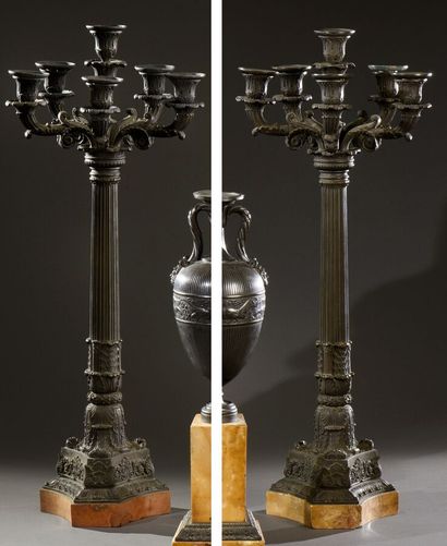 null A pair of large patinated bronze torchères with a fluted shaft on a triangular...