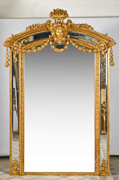 Grand miroir à parecloses en bois doré à décor de mascaron, guirlandes et vases de...