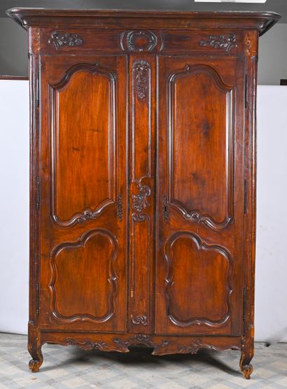 ARMOIRE en bois naturel à deux portes moulurées et sculptées d'agraffes, petits pieds...