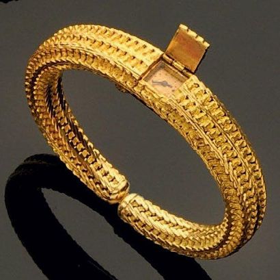 BOUCHERON Bracelet montre de dame articulé en or jaune, cadran escamoté, de la maison...