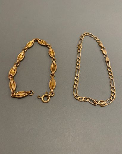 null Two 18k (750 thousandths) yellow gold bracelets, one with a curb chain, the...