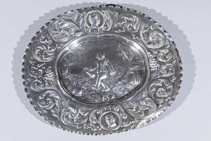 null Small oval silver dish with central decoration of happy drinker in a landscape;...