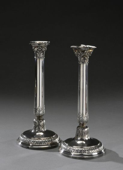null Pair of silver candlesticks, the round base with umbilical water leaves and...