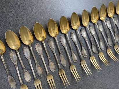 null Set of twelve silver and vermeil dessert spoons and forks, with chased foliage...