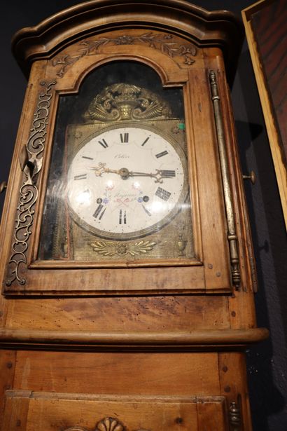 null Straight clock in walnut, opening to a door with carved scrolled panels and...