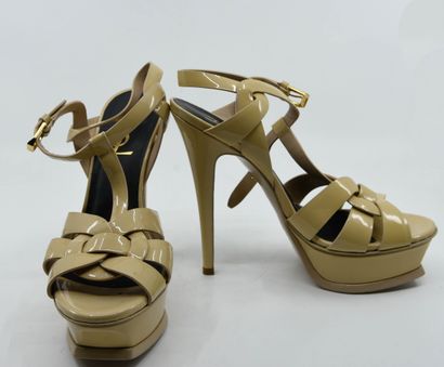 null YVES SAINT LAURENT 
Pair of Tribute pumps in beige patent leather, strap closure...