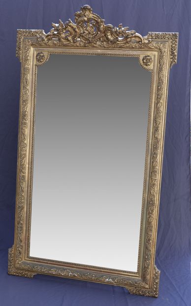 Grand miroir en bois et stuc doré à décor...