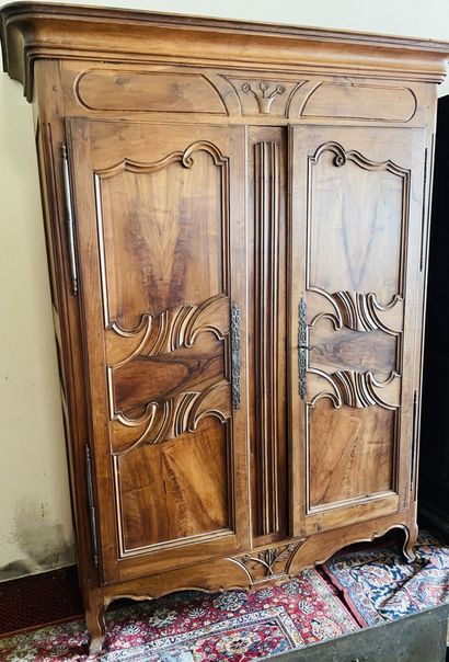 null Armoire en noyer mouluré et sculpté à décor de paniers fleuris et branchages....