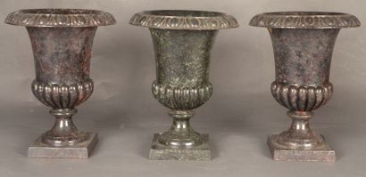 null Trois vases de forme antique à décor de godrons en fonte émaillée imitant le...
