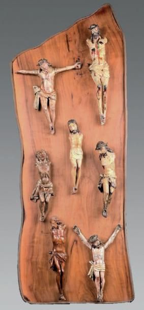 null Sept statuettes de Christ en croix polychrome ou en bois naturel, sur une plaque...