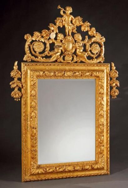  Miroir rectangulaire en bois doré sculpté d'une forte moulure de feuilles. Fronton...