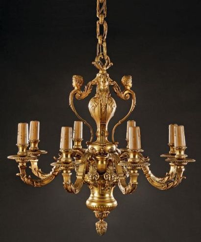  Important lustre en bronze doré à huit branches de lumière à attaches mascarons,...