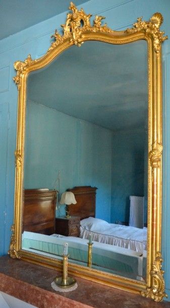 null Important miroir en bois et stuc doré à décor rocaille, le fronton orné d'un...