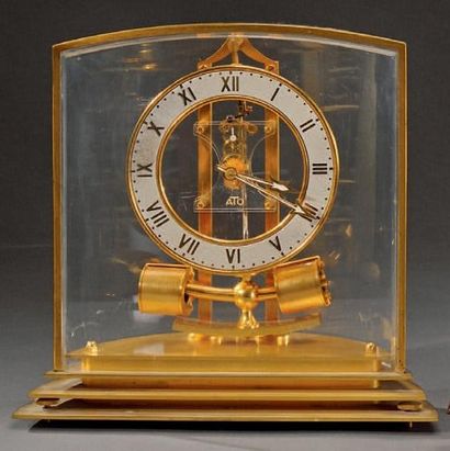 ATO Pendule en laiton doré, le cadran émaillé blanc et à chiffre romain H. 24 cm...
