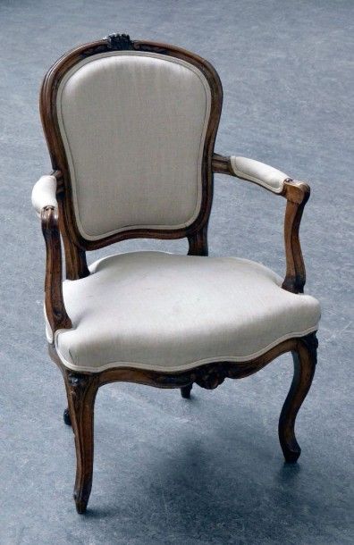 null Un fauteuil cabriolet, en noyer mouluré et sculpté de fleurettes et feuillages,...