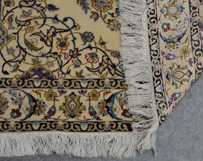 GHOUM Tapis laine et soie à champ beige, décor d'une rosace centrale et frise fleurie,...