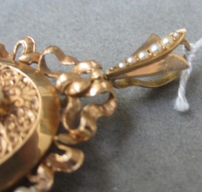 null Broche ancienne de forme ovale en or jaune à décor ciselé surmontée d'un noeud...