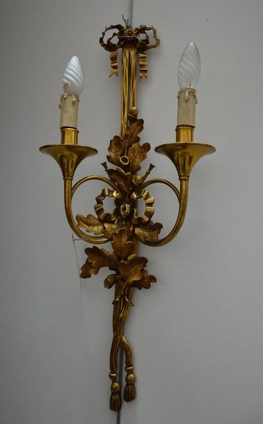 null Suite de quatre appliques à deux lumières en bronze doré à décor de cors, glands...