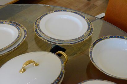 LIMOGES Service de table en porcelaine à décor de fleurs sur fond bleu, bord doré,...