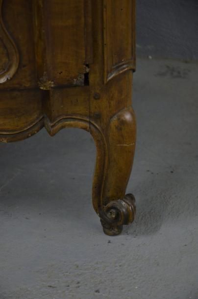 null Commode en noyer mouluré et sculpté. La façade cintrée en arbalète ouvre par...