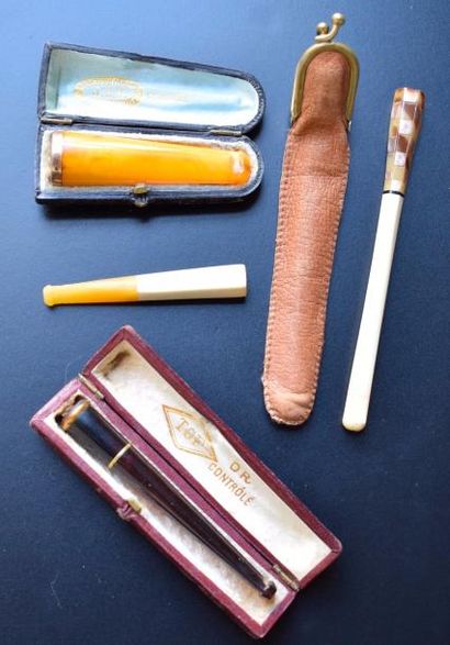 null Quatre fume-cigarettes en ivoire, ambre et écaille, dont deux montés en or 750...
