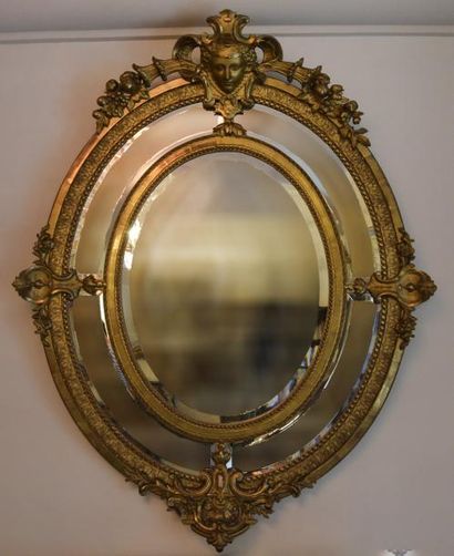 null Miroir ovale à parcloses en bois et stuc doré à décor de tête de femme et cornes...