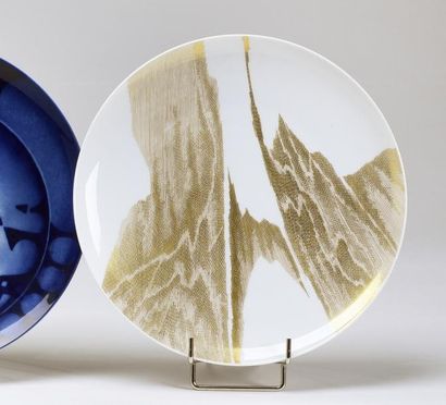 James GUITET (1925-2010) 
Assiette en porcelaine émaillée blanche à décor doré
Manufacture...