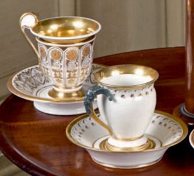 null ** Deux tasses et sous-tasses en porcelaine à décor or de forme balustre, l'une...