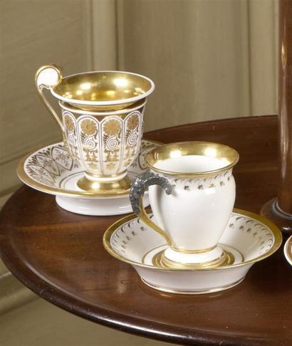 null ** Deux tasses et sous-tasses en porcelaine à décor or de forme balustre, l'une...