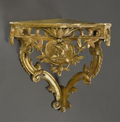 null Console d'angle en bois doré sculpté à ceinture ajourée, centrée d'un médaillon...