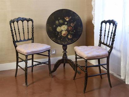 MOBILIER Paire de chaises et un guéridon en bois laqué noir et or, à décor de fleurs
Epoque...