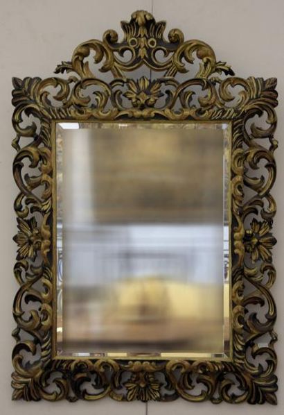 MOBILIER Important miroir en bois sculpté et ajouré doré et laqué noir.
H. 142 cm...