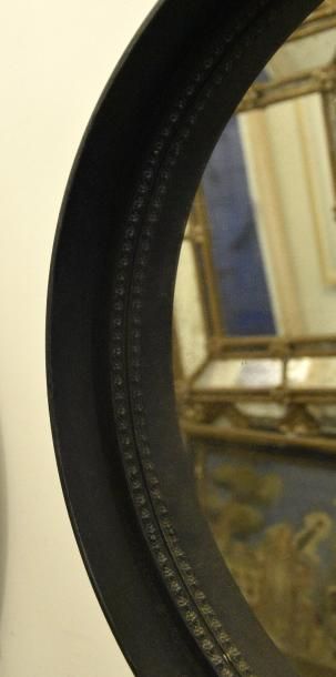 TRAVAIL DES ANNÉES 1970 Miroir circulaire, l'encadrement en fer forgé simulant une...
