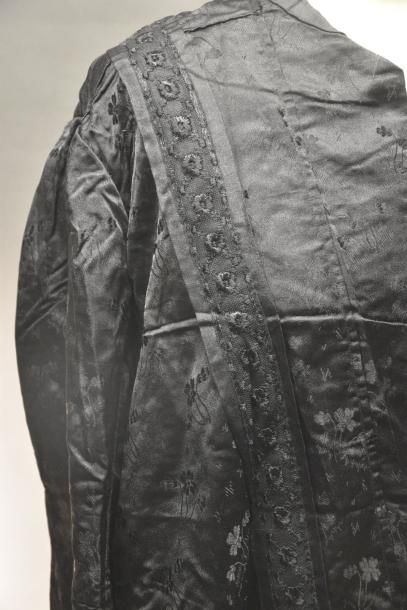 null Robe, vers 1900
Façonné de soie noir à semis de fleurettes, corsage boutonné...