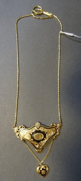 null Collier en or jaune 18K (750/°°) maille forçat centrée d'un motif à décor rocaille...