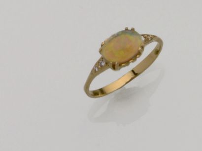 null Bague en or jaune centrée d'un cabochon d'opale épaulé de diamants taille brillant
TDD...