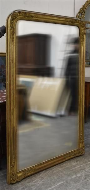 MOBILIER Grand miroir en bois et stuc doré, orné aux coins de guirlandes de fleurs...