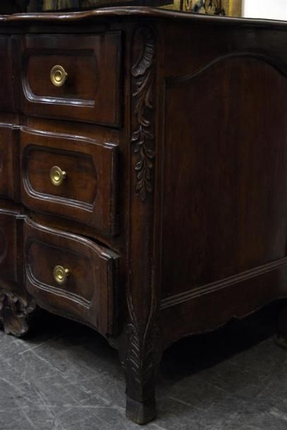 MOBILIER Commode arbalète en noyer à trois tiroirs à réserves moulurées. Les montants...