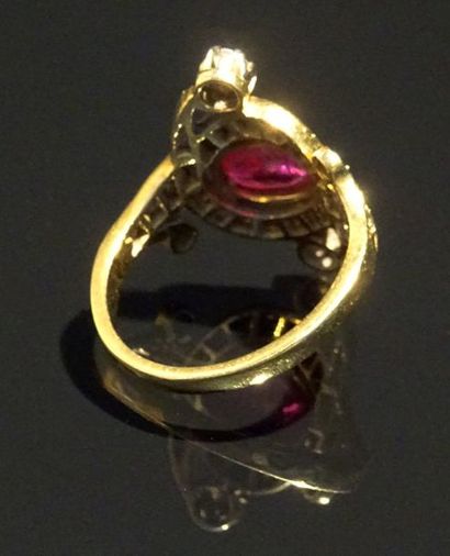 null Bague en or jaune 18K (750/°°) formant des volutes centrée d'un rubis ovale...