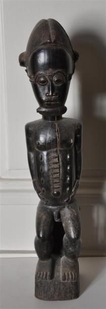 null BAOULE - COTE D'IVOIRE Figurine en bois sculpté patiné figurant un homme assis...